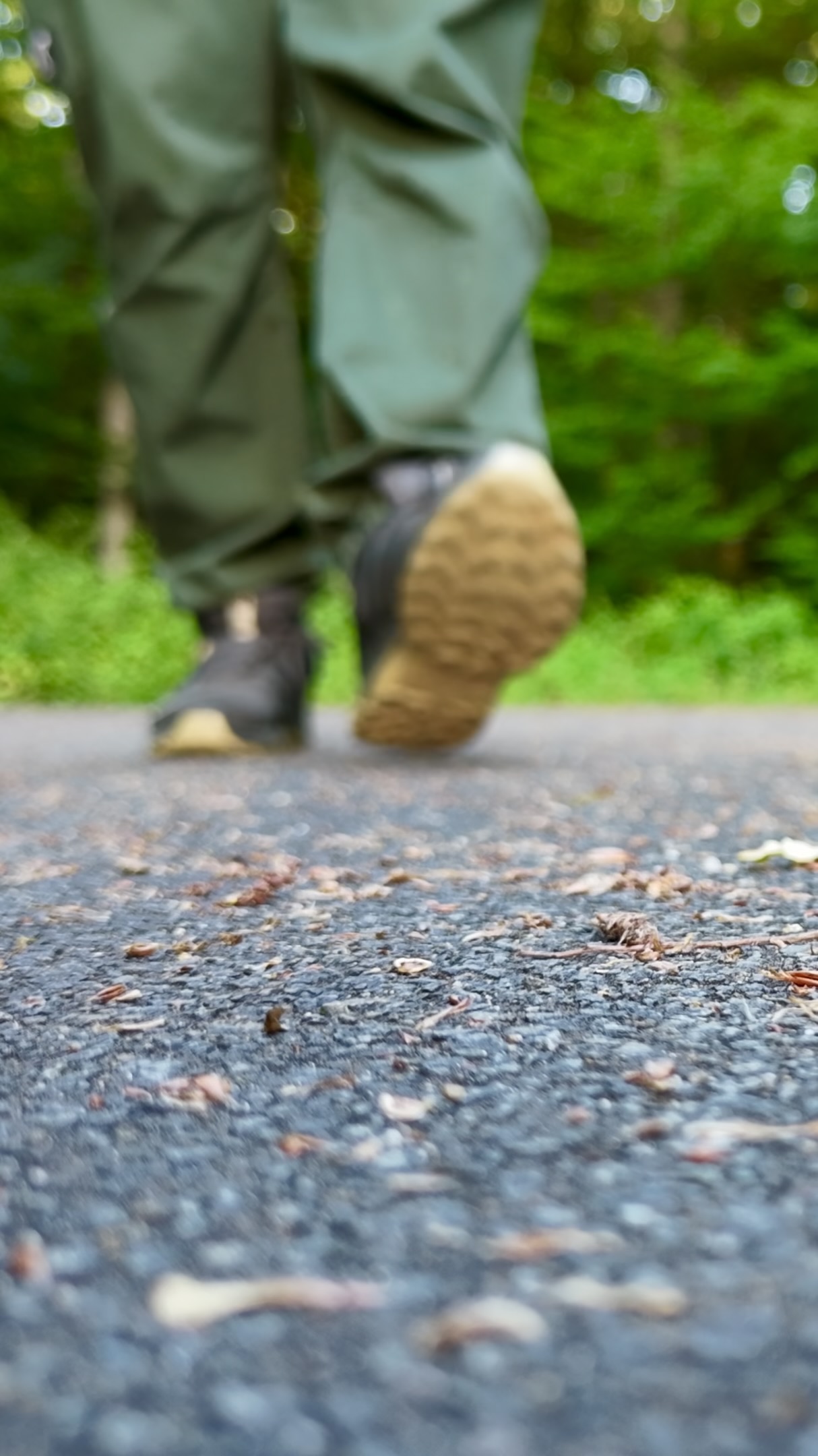 Schuhe beim Gehen auf dem alten Asphaltweg des Depotgeländes