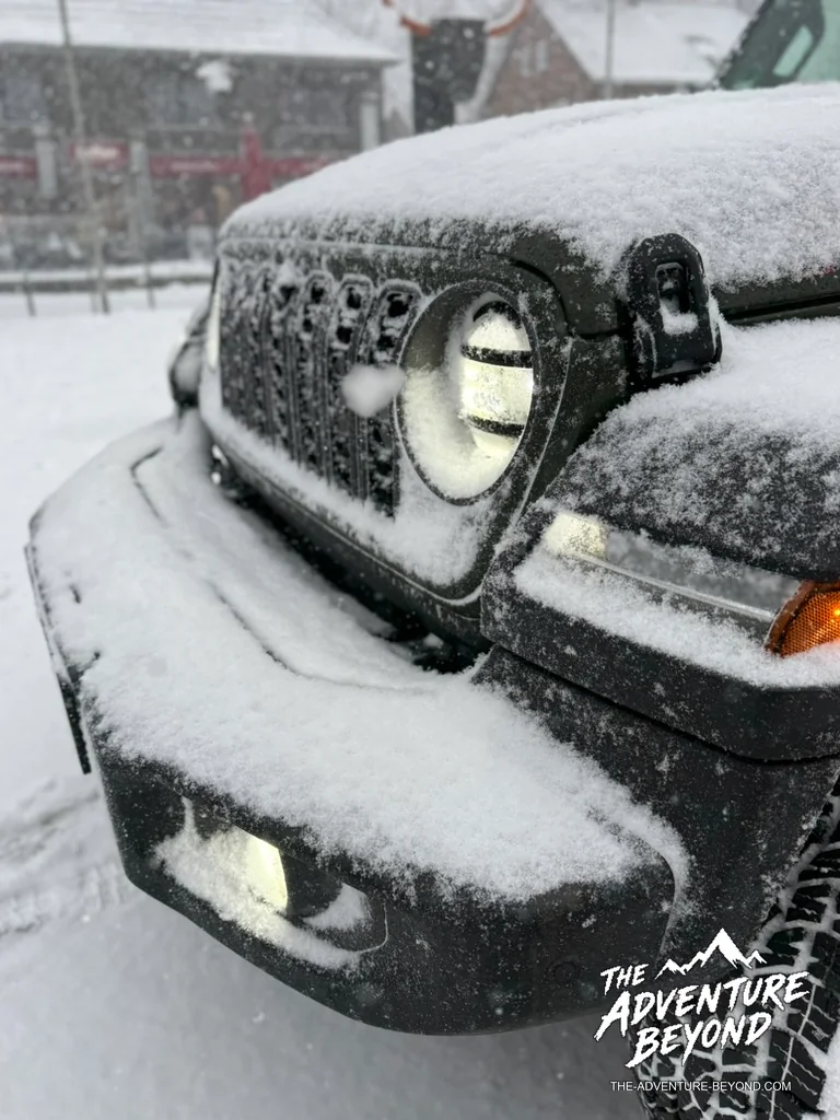 Schneebedeckter Kühlergrill und leuchtender Scheinwerfer