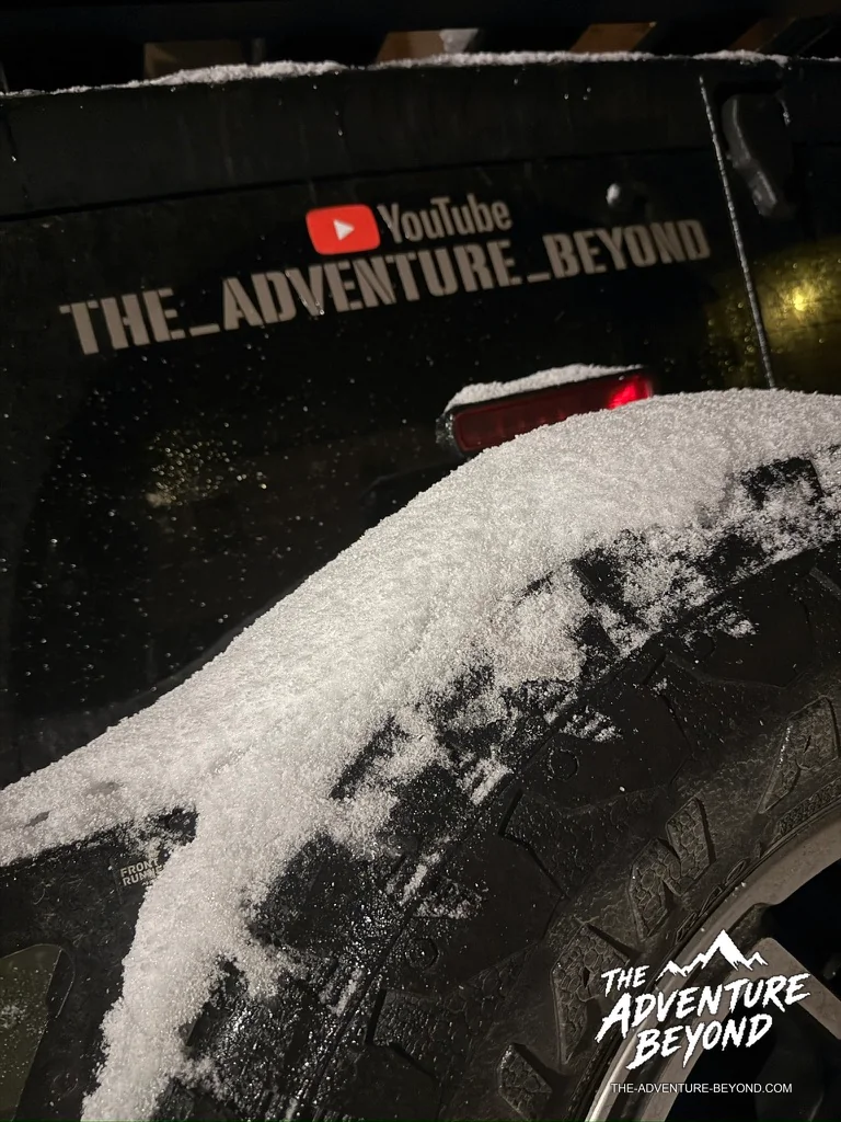Schnee auf dem Reserverad des Jeeps bei Nacht