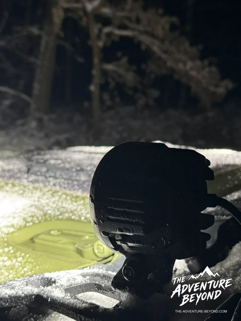 Zusatzscheinwerfer über der verschneiten Motorhaube bei Nacht