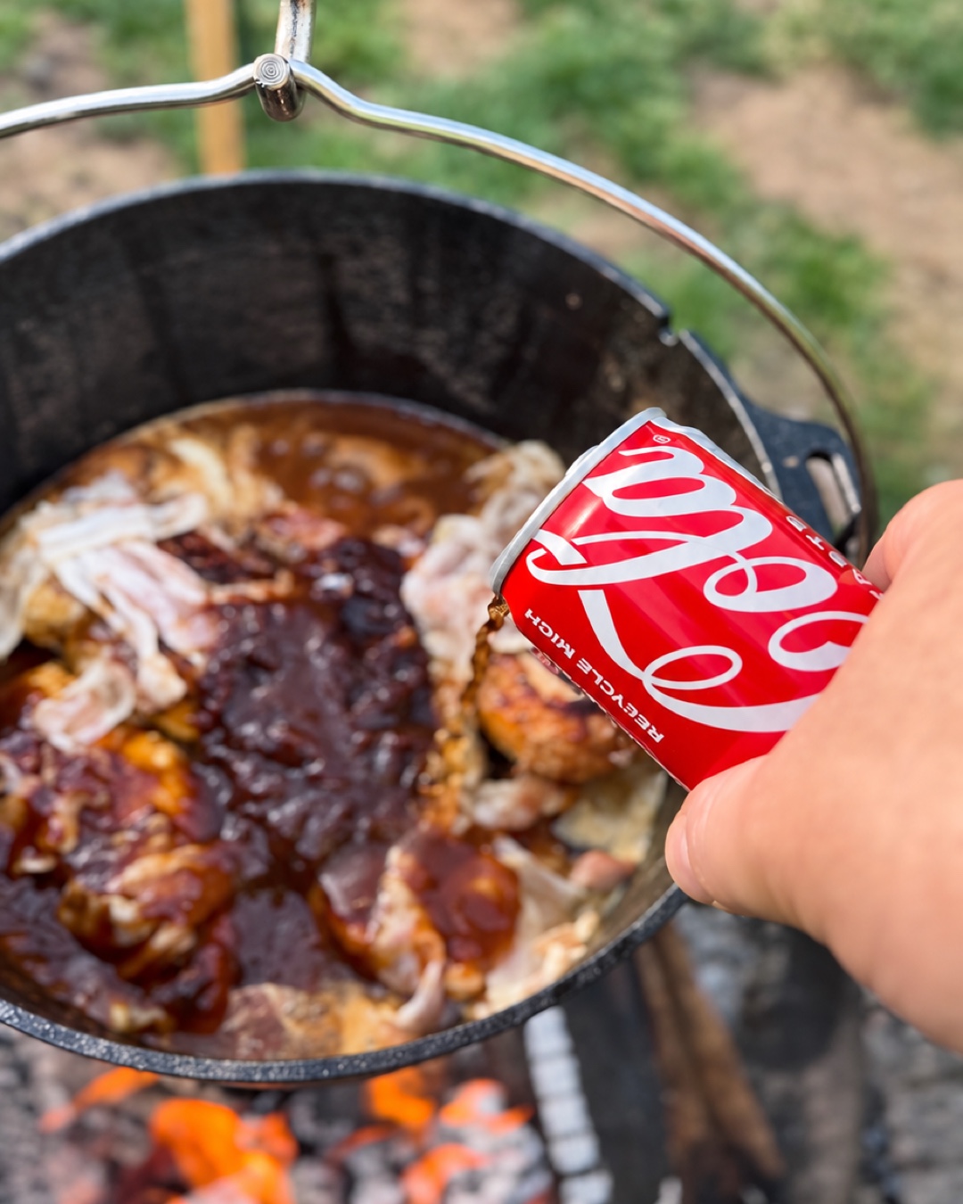 Cola wird zur BBQ-Soße und zum Hähnchen in den Dutch Oven gegossen.