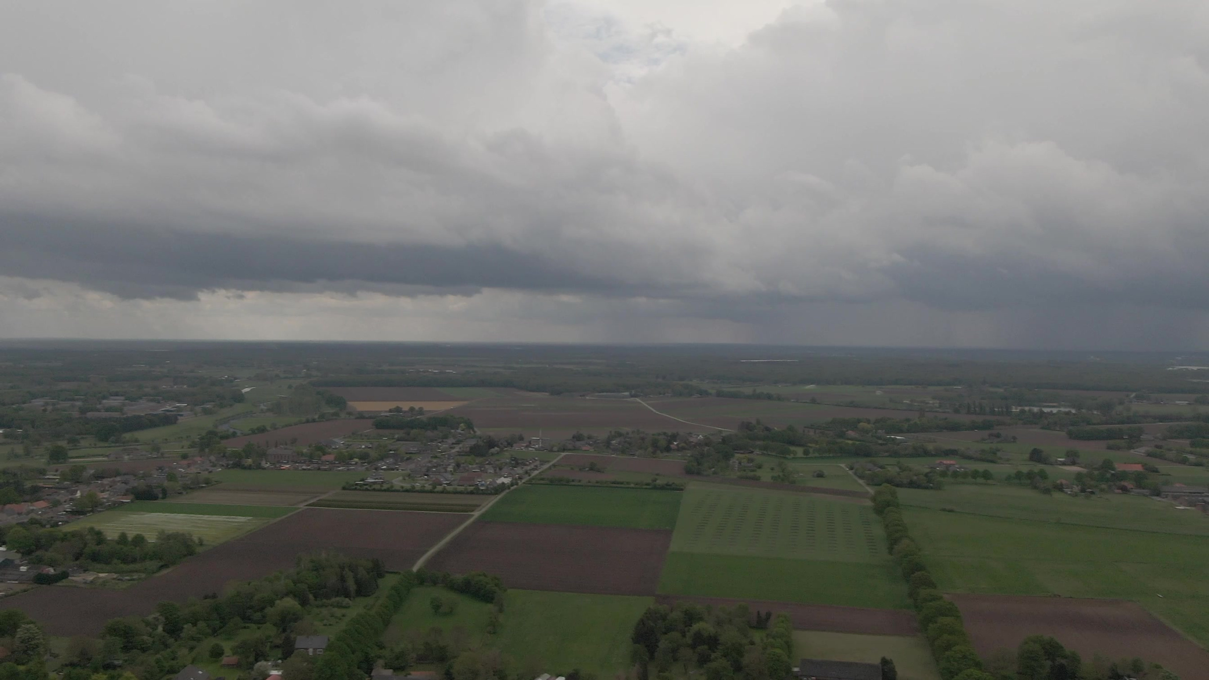 Donkere wolken boven de velden.
