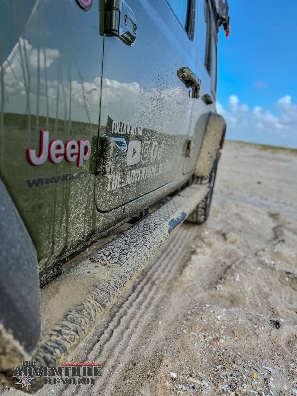 Sand und Spuren des Strandausflugs an Tür und Trittbrett.